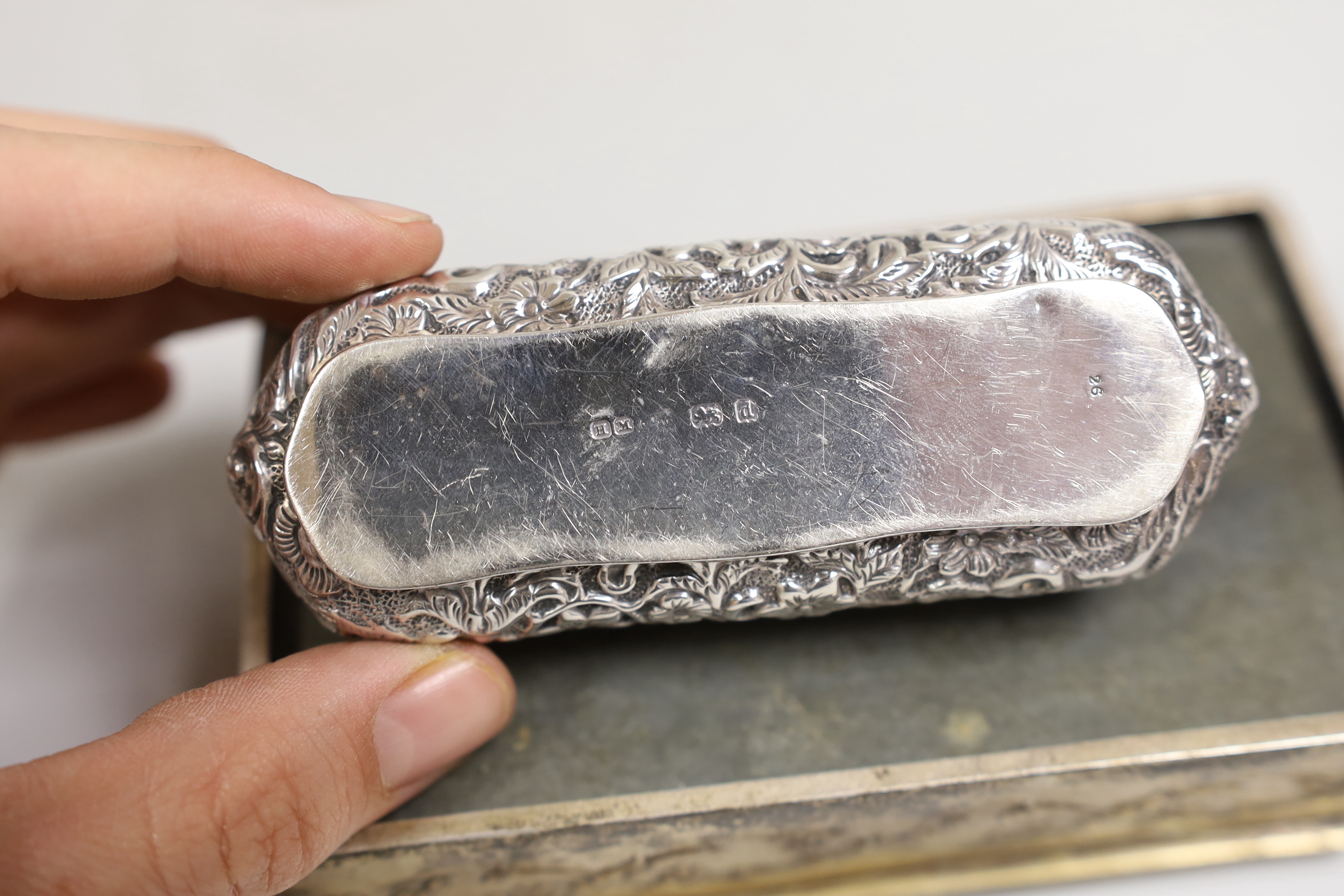 An Edwardian repousse silver mounted trinket box, Birmingham, 1904, 13.8cm, one other smaller repousse box and a silver topped glass scent bottle.